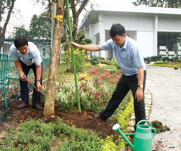 Ông Phạm Xuân Trình trồng cây trong khuôn viên khu trưng bày sản phẩm Phong Phú